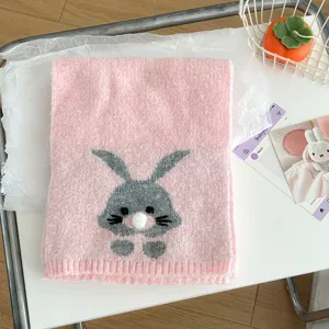 Close-up of a cute pink knitted scarf featuring a grey bunny pattern for autumn and winter.