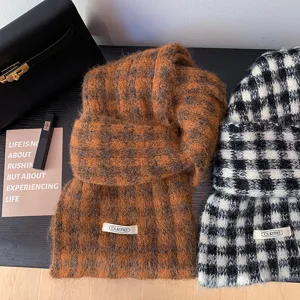 Close-up detail of cozy plaid winter knitted scarves, showing soft texture and vintage pattern.