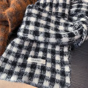 Cozy black and white plaid knit scarf detail showcasing soft fuzzy texture and classic design.