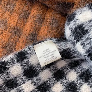 Detail shot of the soft knitted winter scarf showing the material composition label clearly.