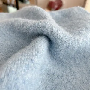 Light blue knitted scarf detail close-up, soft fuzzy woolen texture for autumn winter.