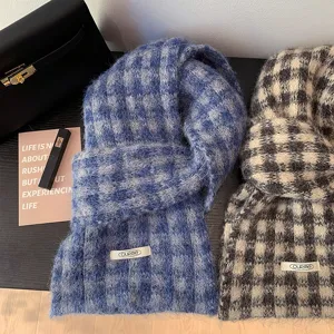 Close-up detailed view of soft fluffy plaid winter scarf texture and cozy fringe design.