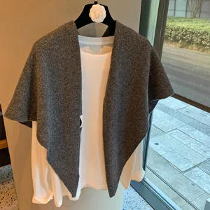 Dark gray hollow knit shawl cape matched with white t-shirt, elegant autumn winter wear.