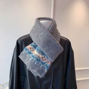 Close-up detail of the stylish grey knitted fair isle scarf with blue geometric pattern.