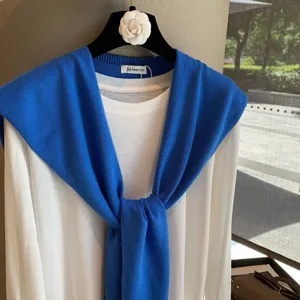Blue knit shawl layered white long sleeve t-shirt detail view, soft cozy fabric top.