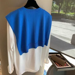 Blue knitted shawl layered with white long-sleeve top, stylish daily wear for women.