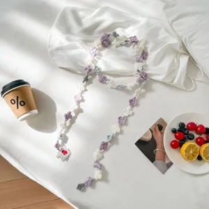 Detailed shot of handmade crochet flower lace trim accessory in purple and white.