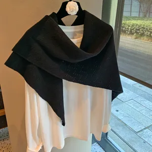 Detail view of the elegant hollow knit triangular scarf shawl, solid black stylish outerwear piece.