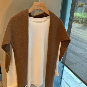 Cómodo chal de punto marrón combinado con top blanco de manga larga, estilo casual de invierno chic.