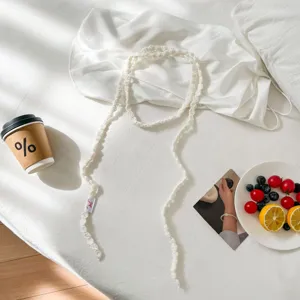 Detailed close-up view of a handmade white crochet choker scarf in aesthetic flat lay.