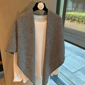 Mantón capa de punto a rayas blancas y negras de mujer otoño invierno moda elegante.