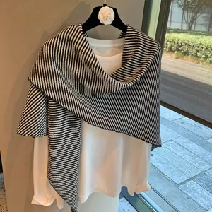Detalle de chal de punto a rayas blancas y negras, textura suave y diseño elegante invierno.