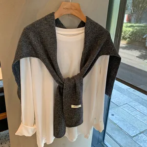 Detalle de chal de lana y top blanco manga larga, estilo casual, atuendo de otoño.
