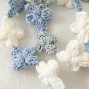 Close-up detail of crochet flower lace trim with blue and white threads for DIY sewing.