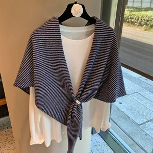 Detalle del chal triangular de punto a rayas con camiseta blanca, gran estilo elegante.