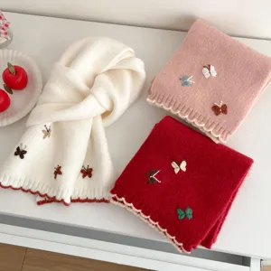 Detailed close-up of Korean style cute butterfly embroidery knit scarf, soft winter warm accessory.
