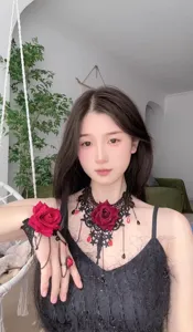 Detail view of gothic black lace rose choker necklace bracelet and ring set with red accents.