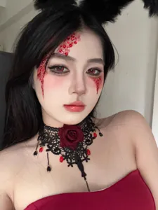Close-up of gothic black lace rose choker necklace with dark red teardrop rhinestones.