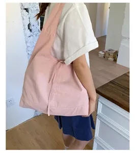 Pink canvas tote bag detail view, large capacity shoulder bag for daily casual commute use.