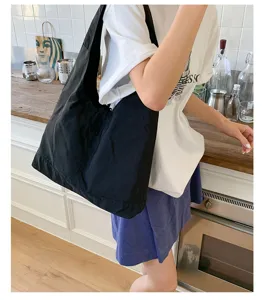 Detailed view of large black canvas shoulder tote bag, casual daily commuting lifestyle scene.