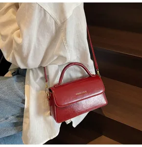 Sac à bandoulière rétro en cuir PU rouge avec poignée élégante et détails dorés.