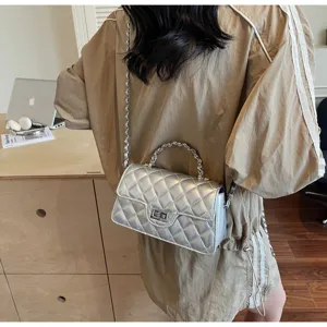 Detail shot of a stylish silver quilted chain crossbody handbag for women, elegant daily wear.