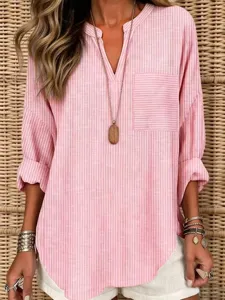 Gros plan detail de la chemise ample a poche rayée rose decontractee col en V doux.
