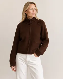 Detail view of brown zip-up knit cardigan featuring ribbed collar, cuffs, and front pockets.