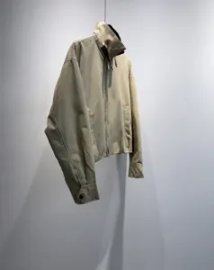 Vista di dettaglio di una elegante giacca corta da donna cachi con colletto a contrasto e zip.