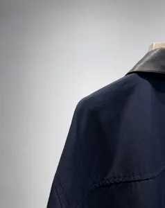 Vista di dettaglio di giacca corta da donna blu navy con colletto in pelle PU a contrasto e zip.