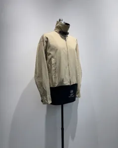 Giacca corta da donna in colore beige con collo alto e chiusura a zip dettagliata.
