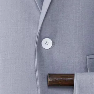 Grey mens suit jacket close up front view showing lapel button and fabric texture details.