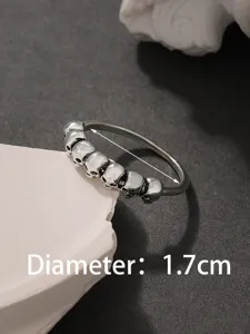 Primo piano dettaglio anello teschio punk in argento, fascia con teschi multipli, 1.7cm