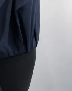 Vista dettagliata della trama della giacca scura da donna, con un design elegante e pulito.