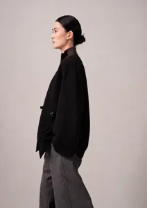 Close-up detail view of the elegant black cashmere wrap coat featuring a stylish belt and V-neck.
