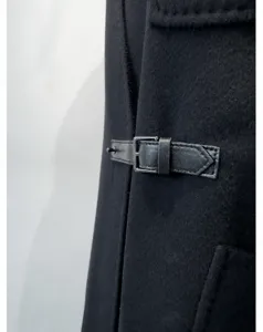 Black wool cashmere coat detail featuring a stylish leather waist belt with metal buckle.
