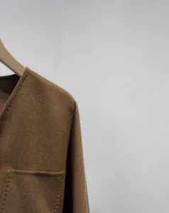 Detail view of short cashmere coat, V-neck wrap design with pocket, premium wool fabric.