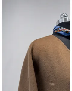 Close-up detail of women's short cashmere wrap coat V-neck shoulder and collar texture.