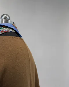Detail shot of brown cashmere wool short coat on mannequin with colorful silk scarf.