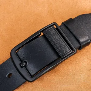 Cinturón de cuero genuino casual para hombre con hebilla metálica negra y placa decorativa.