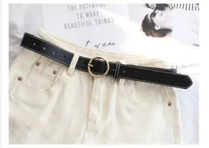 Black leather belt women stylish minimalist waist belt with gold round buckle for jeans detail view