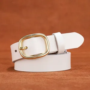 Close-up detail of a white leather belt with a vintage brass metal pin buckle on leather.