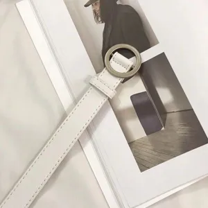 Minimalist white leather belt with silver round buckle for women, stylish detailed view.