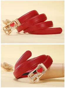 Women red leather belt with gold heart automatic buckle, detailed close-up fashion accessory.