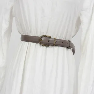 Women vintage genuine leather belt detail with intricate antique brass metal buckle ornament.