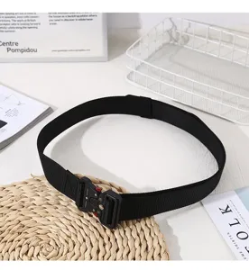 Dettaglio di una cintura in tela nera tattica con fibbia in metallo per un look casual e moderno.