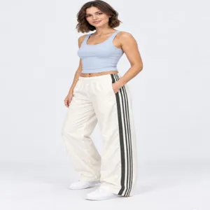 Vista dettagliata dei pantaloni della tuta larghi casual con eleganti strisce laterali nere.