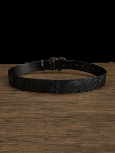 Close-up detail of vintage embossed black leather belt with ornate metallic heart buckle design.