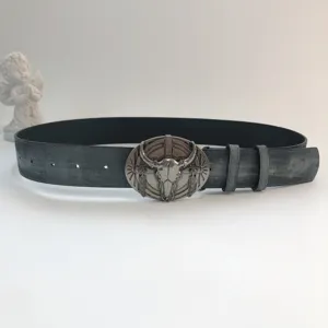 Close-up detail of vintage western leather belt with bull skull metal buckle for women.