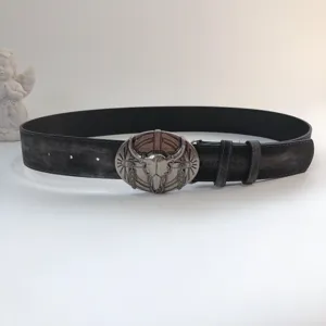 Detailed view of vintage western distressed black leather belt with metal bull skull buckle.